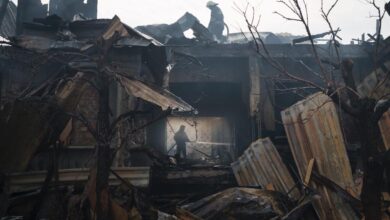 Firefighters work to put out a fire at a house following a Russian attack.